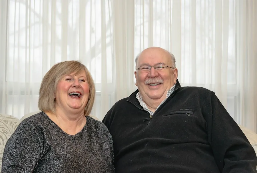 An older couple laughing together at home